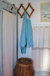 a bathroom with a wicker stool next to a curtain at Το πάνω σπίτι της Μαριάνθης in Márpissa