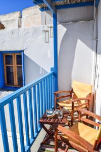 a porch with two chairs and a table on a balcony at Το πάνω σπίτι της Μαριάνθης in Márpissa