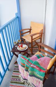een balkon met 2 stoelen en een tafel met een bord eten bij Το πάνω σπίτι της Μαριάνθης in Márpissa