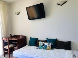 Habitación con cama y TV en la pared. en Résidence Les Sanguinaires - T2 N°16 - Vue Mer en Ajaccio