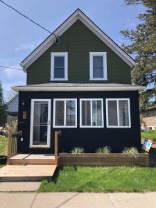 a black house with a wooden porch at Hill Street Hangout in Picton