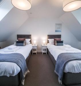 duas camas num quarto com duas mesas e duas lâmpadas em 16 - 3 Bedroom Cottage - LP em Pistyll