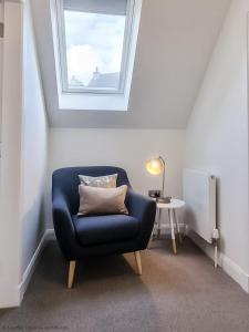 uma cadeira azul num quarto com uma janela em 16 - 3 Bedroom Cottage - LP em Pistyll