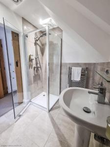 uma casa de banho com um chuveiro e um lavatório branco em 16 - 3 Bedroom Cottage - LP em Pistyll