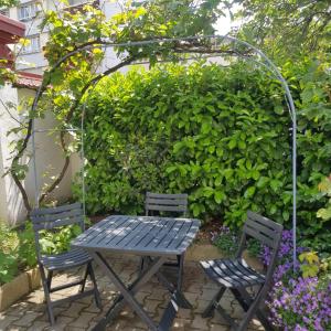 a picnic table and two chairs in a garden at Sainte Cécile 5 - T3 élégant, limineux et central in Vichy +4 photos
