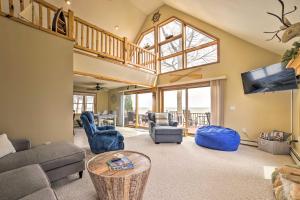 een woonkamer met meubilair en een groot raam bij Waterfront Lake Huron Home - Private Beach! in Tawas City
