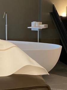 una vasca da bagno bianca seduta accanto a una scala di DIMORA1934 Relax&Comfort a Tirano