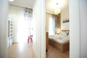 a bedroom with a bed and a chair in a room at ROGA Apartment Valamar in Hamallë