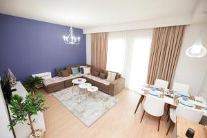ein Wohnzimmer mit einem Sofa und einem Tisch in der Unterkunft ROGA Apartment Valamar in Hamallë