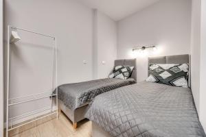 ein Schlafzimmer mit zwei Betten und einem Spiegel in der Unterkunft Central Platinum Apartments 25 in Rybnik