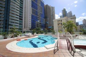 a large swimming pool in a city with tall buildings at Hospedium Princess Hotel Panamá in Panama City