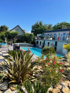 a swimming pool in front of a house with plants at Hotel la piscine in Villers-sur-Mer