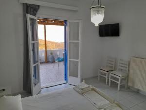 een slaapkamer met een bed en een glazen schuifdeur bij Silver view in Batsi
