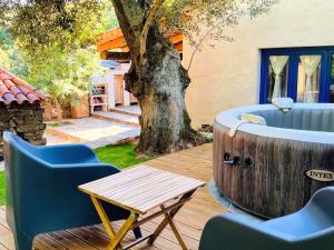 a hot tub with chairs and a table on a deck at Moinho do Maneio in Penamacor