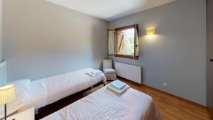 a bedroom with two beds and a window at Los Altos de Escarrilla - tucasaenlospirineos in Escarrilla