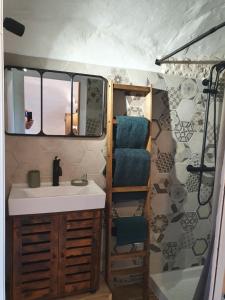 uma casa de banho com um lavatório, um espelho e uma banheira em La Storya em Meyras