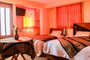 una habitación de hotel con 2 camas y un jarrón sobre una mesa en Amazing Huaraz, en Huaraz