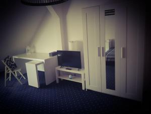 a room with a desk with a computer and a tv at 6 bedroom Private APARTMENT & Lounge in Rostock