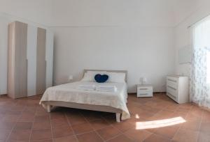 a white bedroom with a bed and a tiled floor at Casa Madda in Ceglie Messapica
