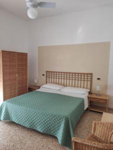 sypialnia z dużym łóżkiem i zielonym kocem w obiekcie Hotel Imperia w mieście Marciana Marina +28 zdjęć