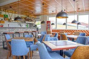 ein Esszimmer mit blauen Stühlen und Tischen in einem Restaurant in der Unterkunft ELEVENROOMS in Belgrad