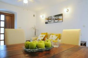 a bowl of green apples on a wooden table at Guesthouse Adriana Cottages in Labin