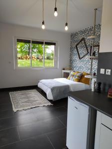 Cet appartement comprend une chambre avec un lit et une cuisine avec une table. dans l'établissement AUBERGE LE GABACHOU, à Montpezat-de-Quercy