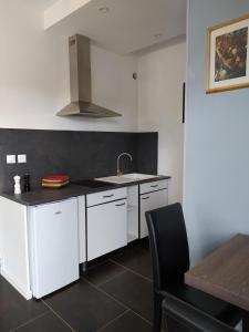 a kitchen with white cabinets and a sink at AUBERGE LE GABACHOU in Montpezat-de-Quercy