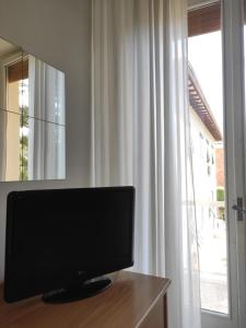 una televisione seduta su un tavolo accanto a una finestra di Hotel Imperia a Marciana Marina