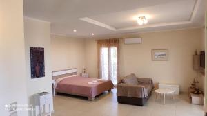 a bedroom with a bed and a couch and a chair at Kalliope Apartments in Tsoukalades +68 photos