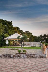 een park met een tuinhuisje en een grote vaas op een stoep bij Villa Patrizia-Luxury Villa in Mottola