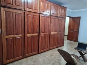 a large group of wooden cabinets in a room at KARIBU G&H Location Meublée Furnished Rental in Yaoundé