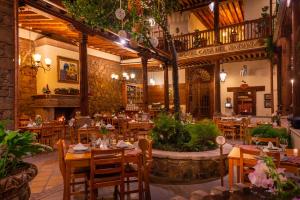 a restaurant with wooden tables and chairs in a room at Hotel Casa del Naranjo in Pátzcuaro