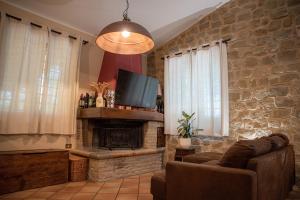 ein Wohnzimmer mit einem Kamin und einem TV in der Unterkunft Residenza San Fortunato in Assisi