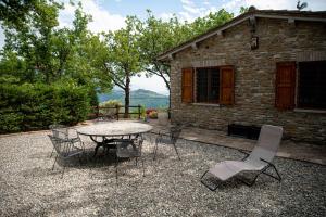 eine Terrasse mit einem Tisch und Stühlen vor einem Gebäude in der Unterkunft Residenza San Fortunato in Assisi