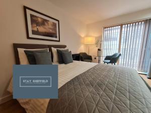 a bedroom with a large bed with a large window at Sheffield City Centre Studio in Sheffield