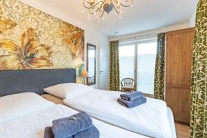 a bedroom with two beds and a painting on the wall at SEASIDE APARTMENTS - TOWNHOUSE in Eckernförde