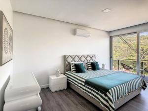 Habitación blanca con cama y ventana en Wild River Villa by LovelyStay, en Ribeira Brava
