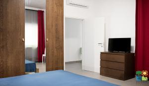 Dormitorio con cama y tocador con TV en Sole & Pepe, en Santa Maria di Castellabate