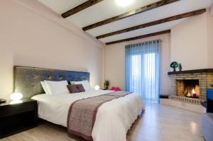 sypialnia z dużym łóżkiem i kominkiem w obiekcie Perivoli Country Hotel & Retreat w Nauplionie +37 zdjęć