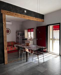 uma sala de jantar com uma mesa e um sofá vermelho em Casa I due Pini em Casa Modica