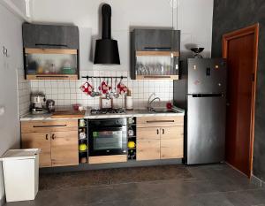 uma cozinha com um frigorífico de aço inoxidável e armários de madeira em Casa I due Pini em Casa Modica