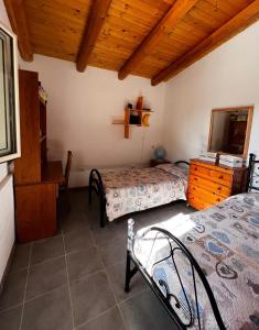 um quarto com 2 camas e um tecto de madeira em Casa I due Pini em Casa Modica