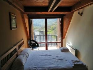 a bedroom with a bed and a large window at Los Altos de Escarrilla - tucasaenlospirineos in Escarrilla +213 photos