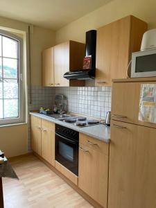a kitchen with wooden cabinets and a stove top oven at das alte Wasserwerk in Bad Bentheim