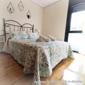 - une chambre dotée d'un lit avec un couvre-lit vert et blanc dans l'établissement RECUERDOS DE ASTURIAS, à Piedras Blancas