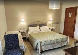 a bedroom with a large bed and a chair at Villa Cristina in Pontelatone