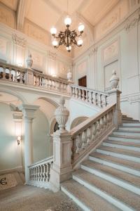 - un escalier orné dans un bâtiment doté d'un lustre dans l'établissement Royal Palace Hotel, à Turin