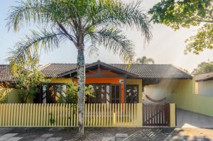 a palm tree in front of a house at Casa Guaratuba-Barra do Saí - "Recanto de Milady" - 80 m da Praia in Guaratuba