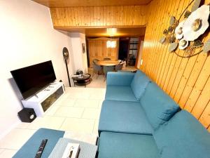 Schöne Ferienwohnung mit Seeblick في ثون: غرفة معيشة مع أريكة زرقاء وتلفزيون